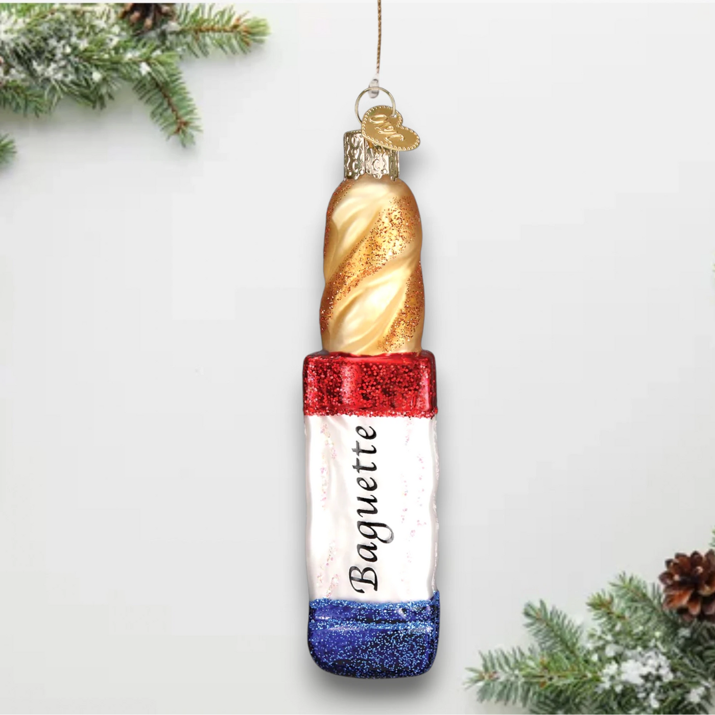 A glittery baguette Christmas ornament featuring a golden loaf and a red, white, and blue tricolor design inspired by the French flag.