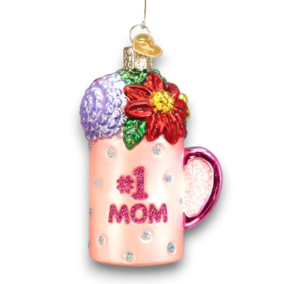 Pink “#1 Mom” mug Christmas ornament with glitter accents and colorful floral decorations, customizable with name and year.