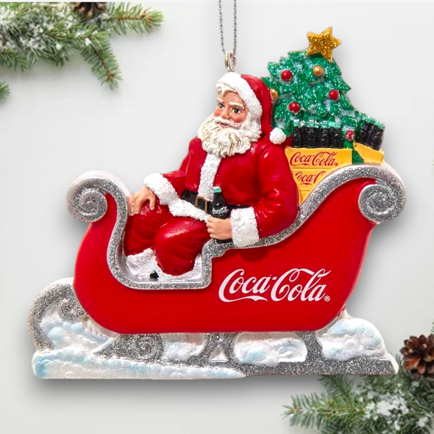 Side view of the Coca-Cola Santa ornament showing intricate details of Santa's sleigh and Christmas decorations with Coca-Cola branding.