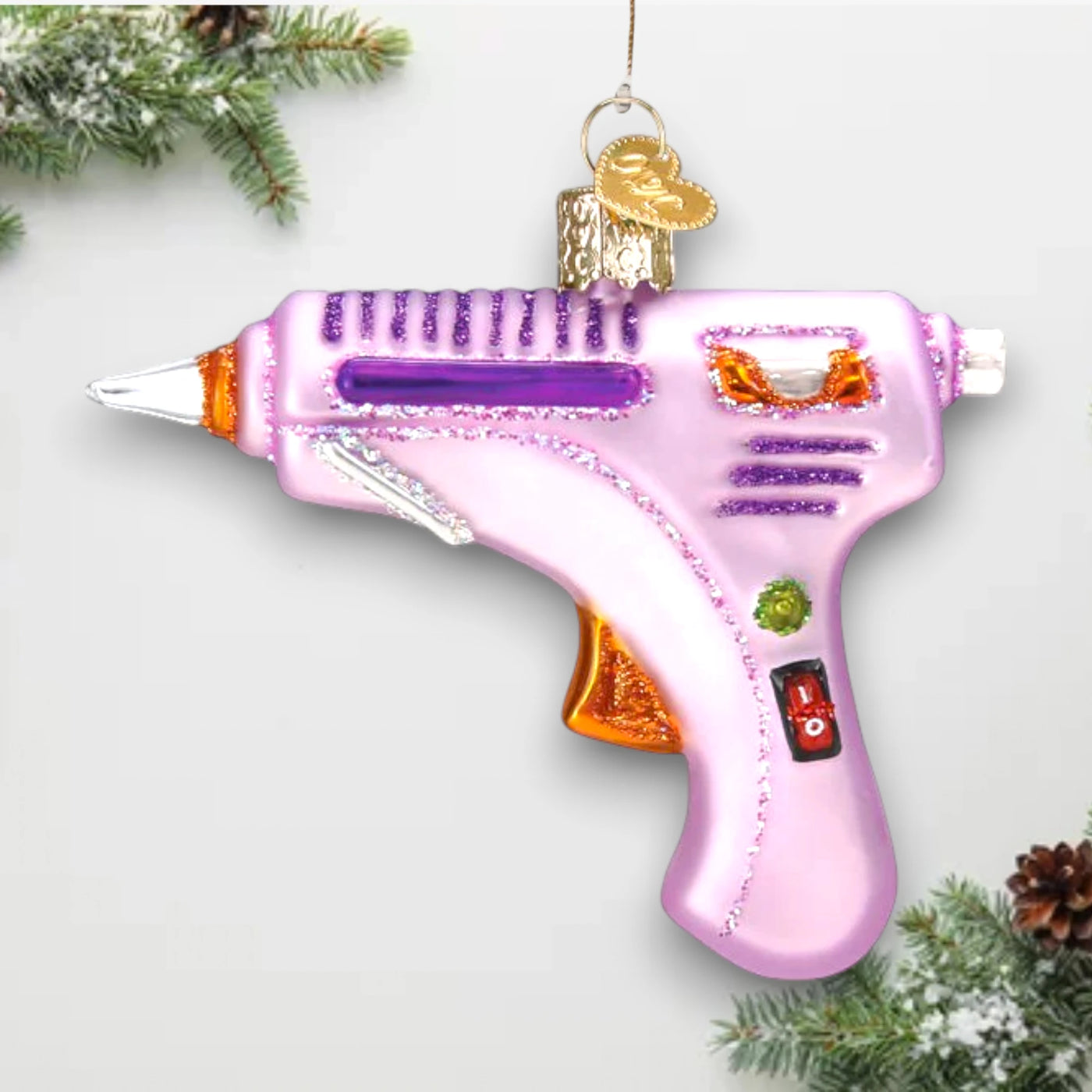 Personalized Hot Glue Gun Christmas Ornament featuring a pink glue gun with glittery purple and orange details, customizable with name and year.