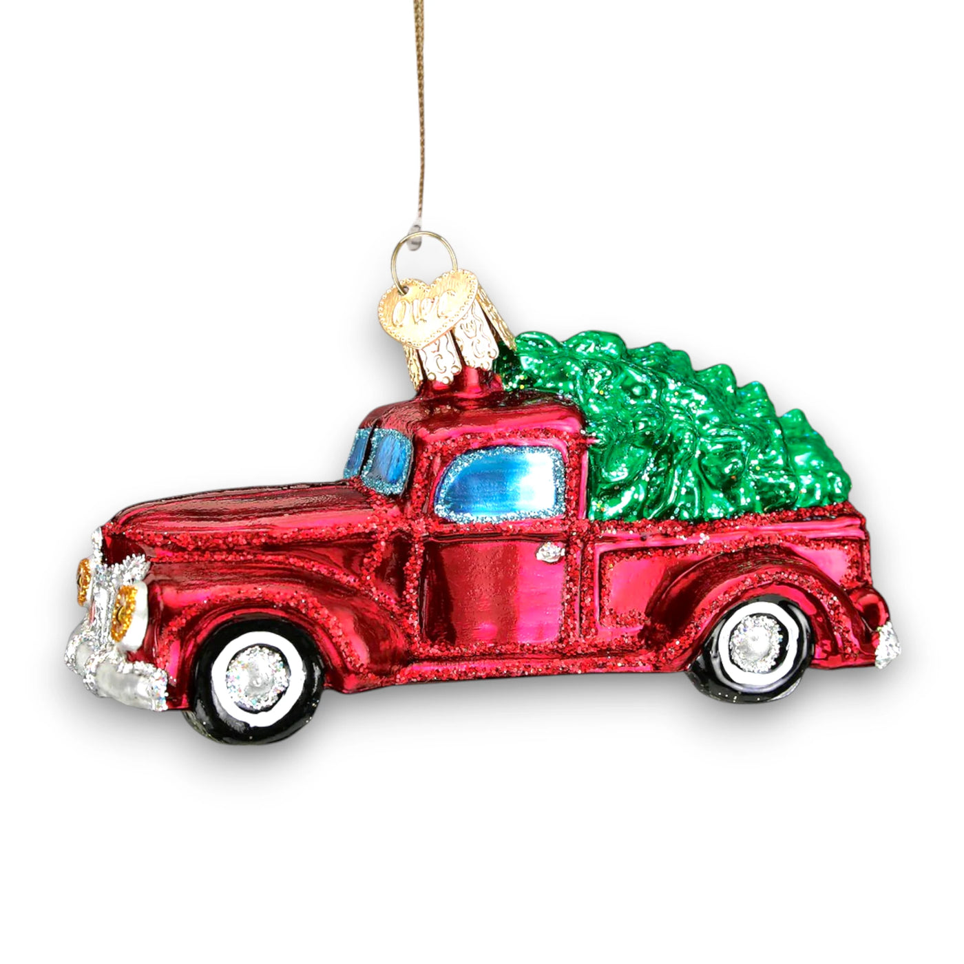 Vintage red truck Christmas ornament carrying a green tree with glitter accents, perfect for holiday decor and gifting.