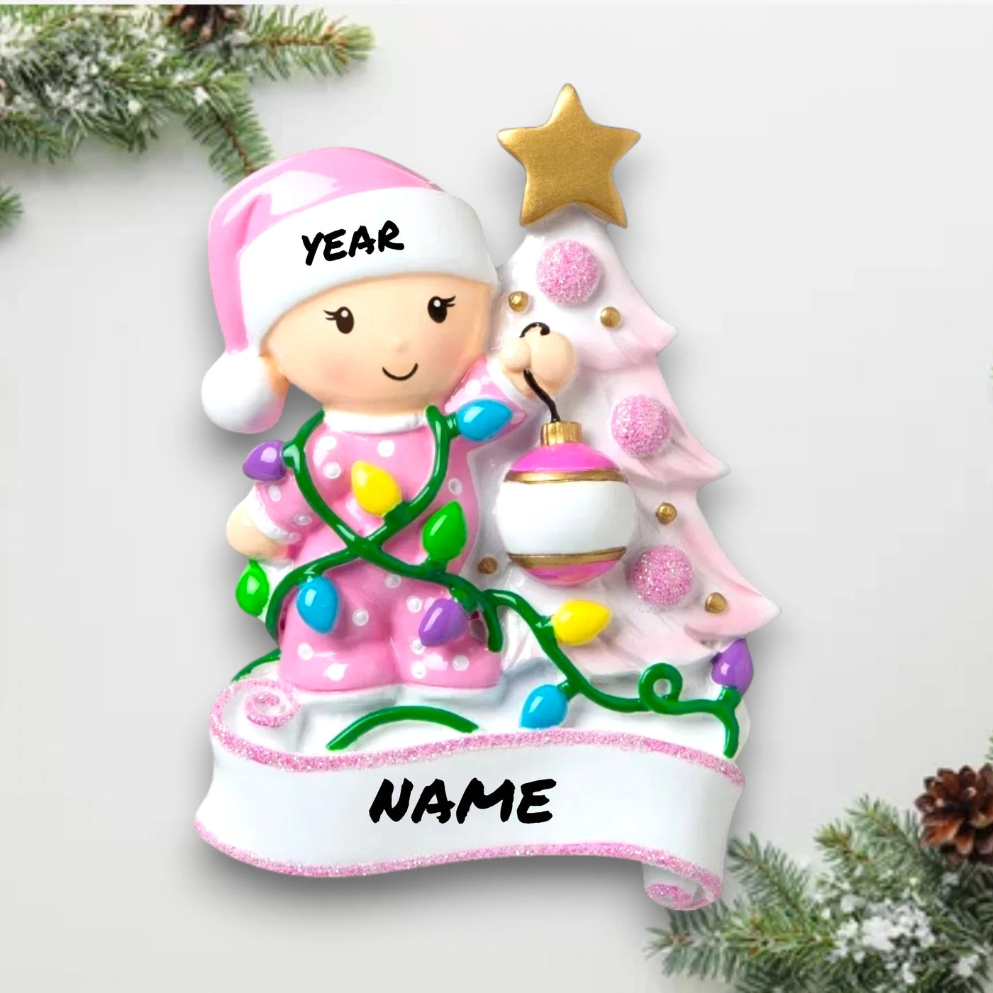 Personalized Baby Decorating A Tree Pink Christmas Ornament with customizable name and year, featuring a baby girl with holiday lights and a decorated Christmas tree.