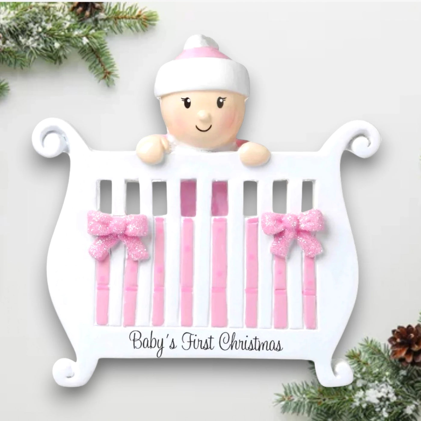 Personalized Baby Girl in Crib Christmas Ornament with customizable name and year, featuring a baby girl peeking over a crib with pink bows and glitter accents.