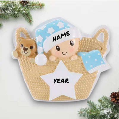 Personalized Baby in Basket Blue Christmas Ornament with customizable name and year, featuring a baby in a cozy basket with a teddy bear and blue accents.