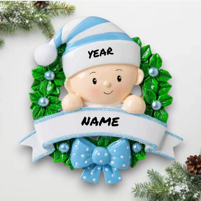 Personalized Baby in Wreath Light Blue Christmas Ornament with customizable name and year, featuring a baby boy in a blue hat surrounded by holly and a ribbon.