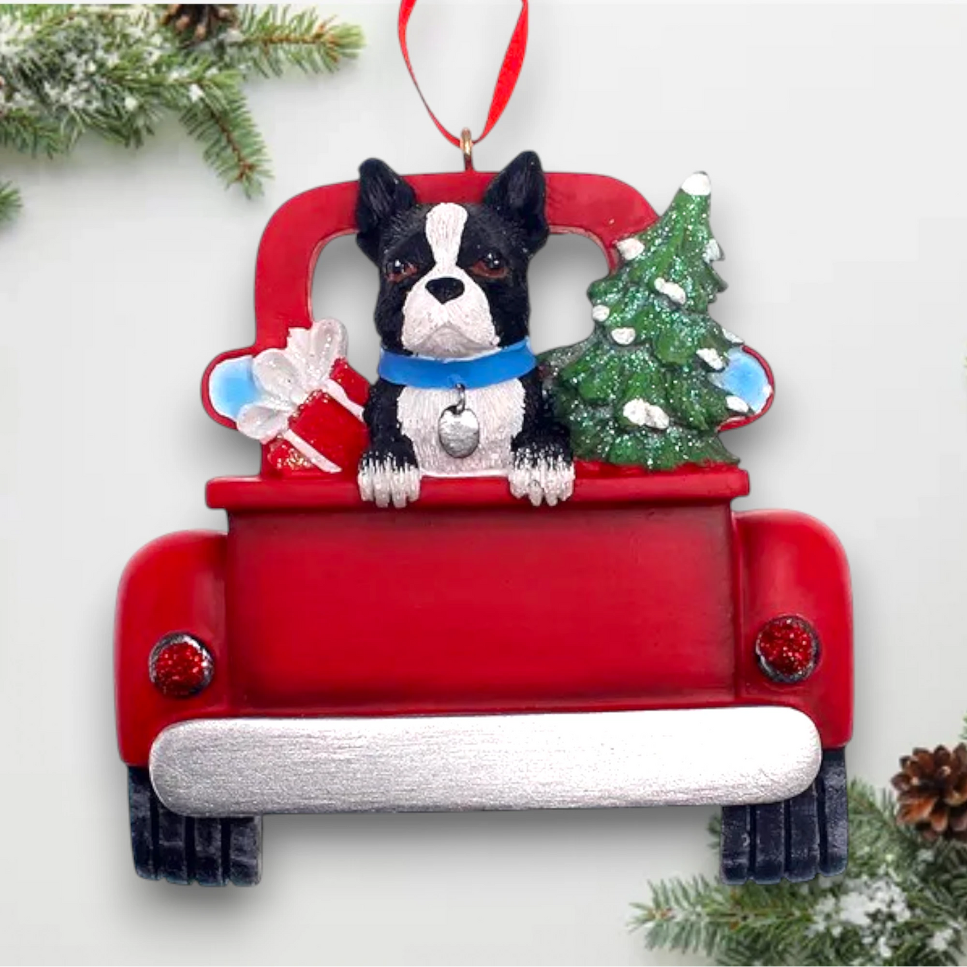 Personalized Boston Terrier In Back Of Truck Christmas Ornament featuring a Boston Terrier, festive Christmas tree, and holiday gifts in a red truck with customizable name and year.