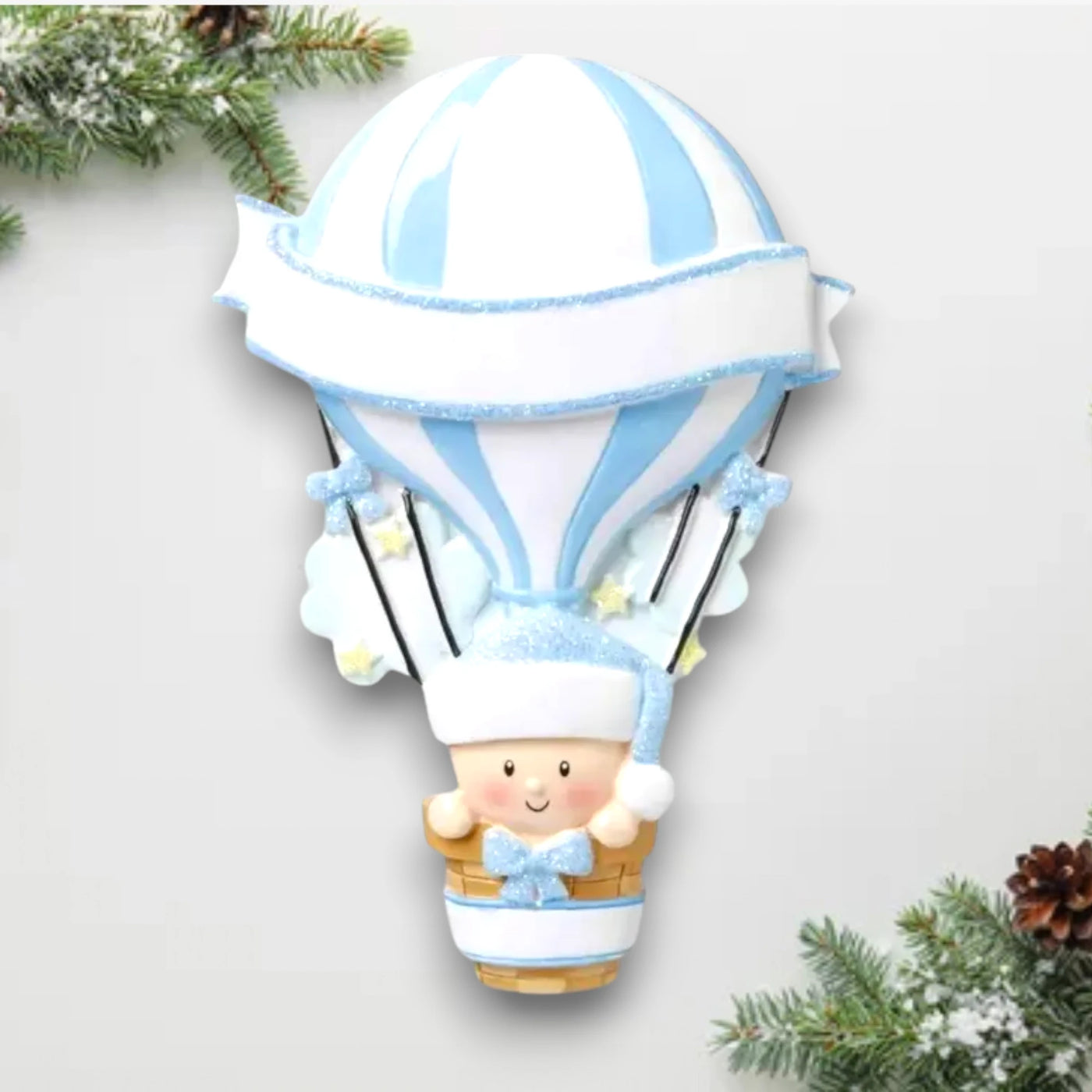 Personalized Hot Air Balloon Blue Baby’s First Christmas Ornament featuring a blue and white striped balloon with baby in basket, customizable with name and year.