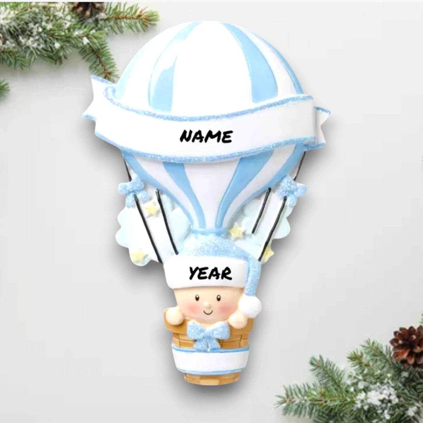 Personalized Hot Air Balloon Blue Baby’s First Christmas Ornament featuring a blue and white striped balloon with baby in basket, customizable with name and year.