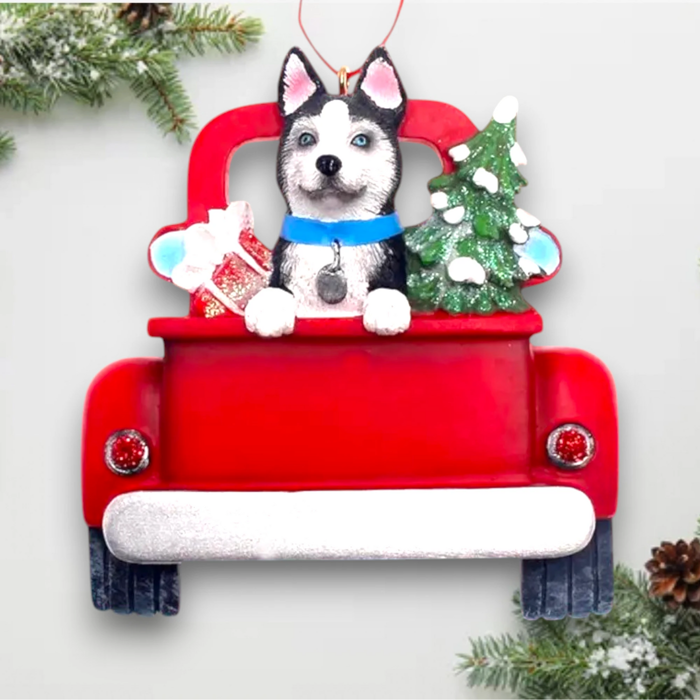 Personalized Husky In Back Of Truck Christmas Ornament featuring a Husky, a festive red truck, a Christmas tree, and a gift, customizable with name and year.
