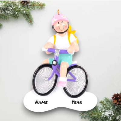 Personalized Little Girl Bike Blonde Christmas Ornament featuring a blonde girl riding a purple bike with a pink helmet and a yellow backpack, customizable with name and year.

