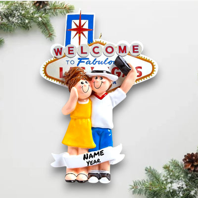 Personalized LOVE IN LAS VEGAS Christmas Ornament featuring a couple in front of the “Welcome to Fabulous Las Vegas” sign with customizable names and year.