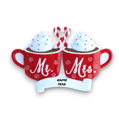 Personalized Mr. & Mrs. Hot Cocoa Christmas Ornament with customizable names and year, featuring two red mugs topped with whipped cream and a candy cane heart.
