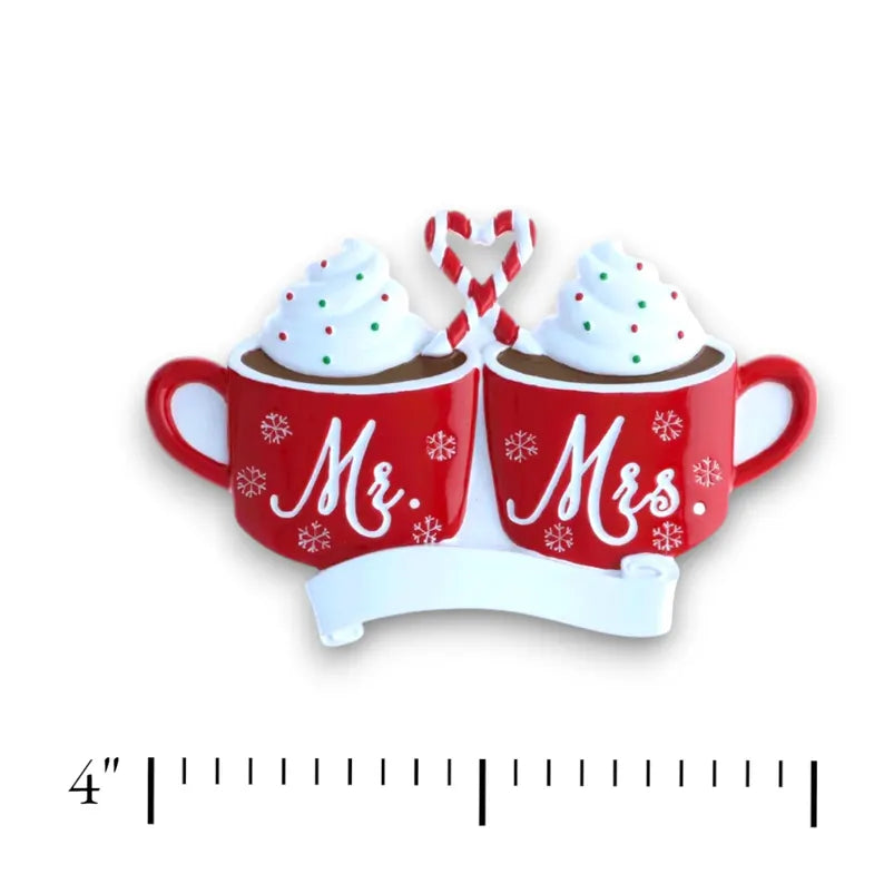 Personalized Mr. & Mrs. Hot Cocoa Christmas Ornament with customizable names and year, featuring two red mugs topped with whipped cream and a candy cane heart.
