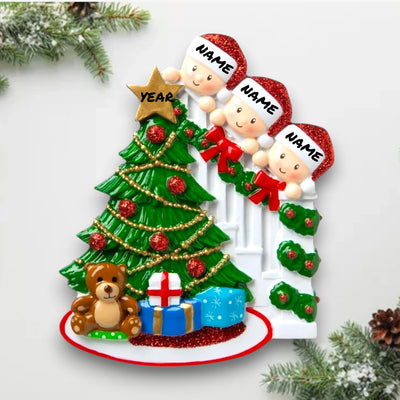 Personalized Peeking Family of 3 Christmas Ornament featuring three family members peeking from behind a decorated tree with customizable names and year.