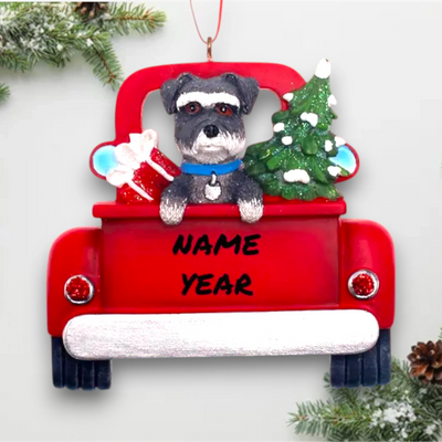 Personalized Schnauzer In Back Of Truck Christmas Ornament featuring a schnauzer, festive red truck, Christmas tree, and gift, customizable with name and year.
