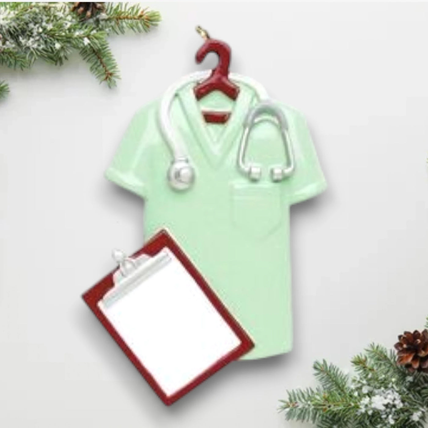 Personalized Scrubs Green Christmas Ornament featuring a scrub top, stethoscope, and clipboard with customizable name and year.