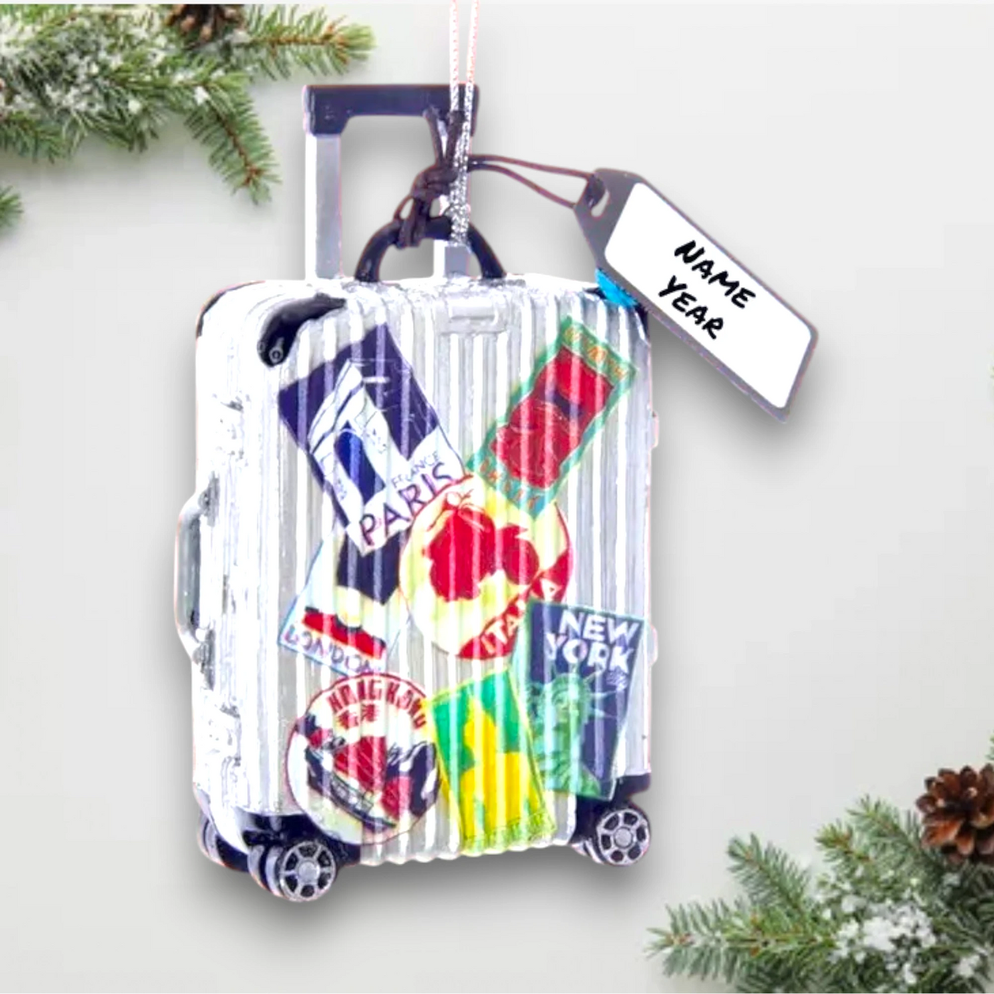 Personalized Travel Luggage Christmas Ornament featuring a suitcase with travel stickers from famous destinations like Paris, New York, and London, customizable with name and year.