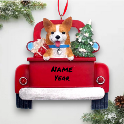 Personalized Welsh Corgi In Back Of Truck Christmas Ornament featuring a Welsh Corgi, Christmas tree, and presents in a red truck with customizable name and year.