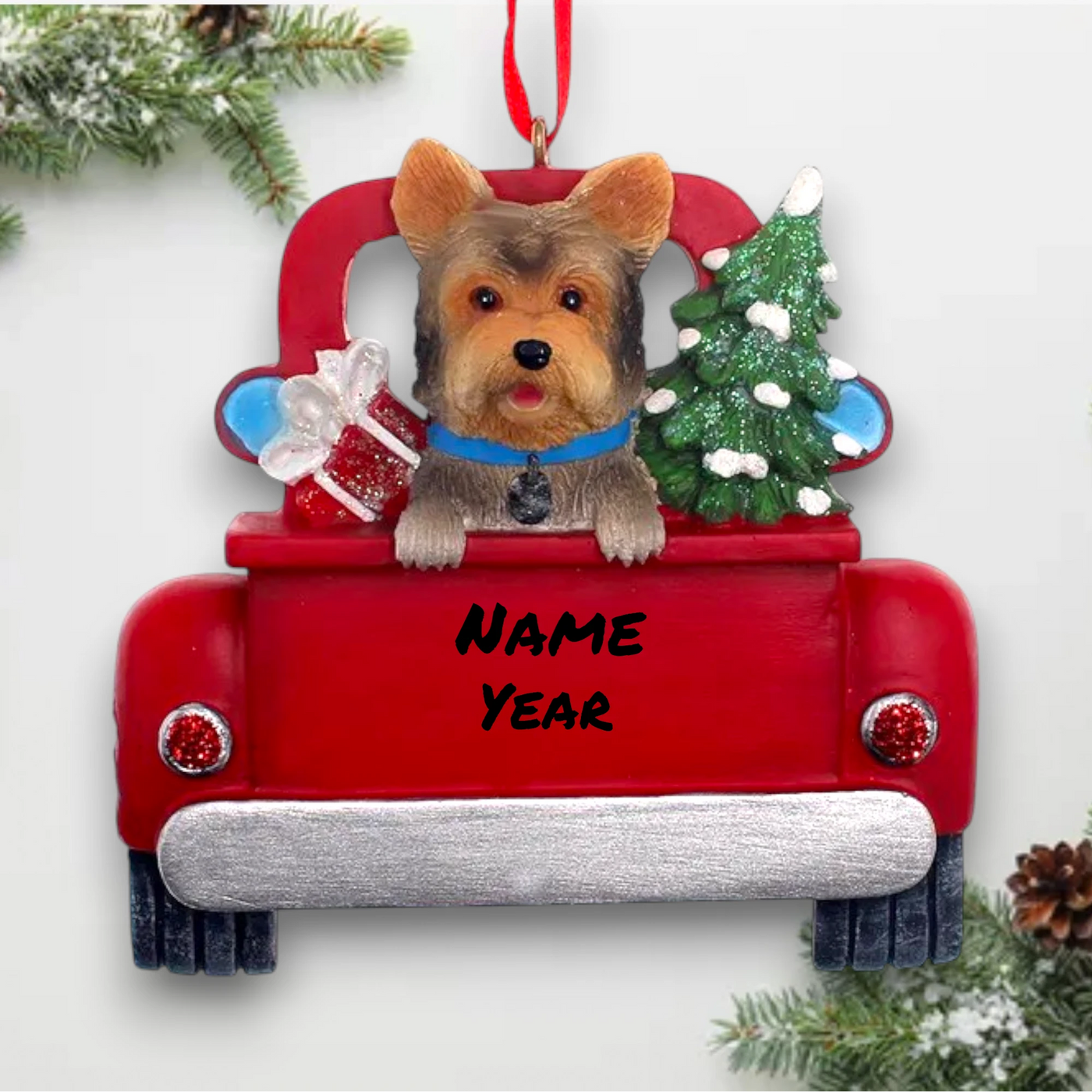 Personalized Yorkshire Terrier In Back Of Truck Christmas Ornament featuring a Yorkshire Terrier, festive Christmas tree, and holiday gifts in a red truck with customizable name and year.