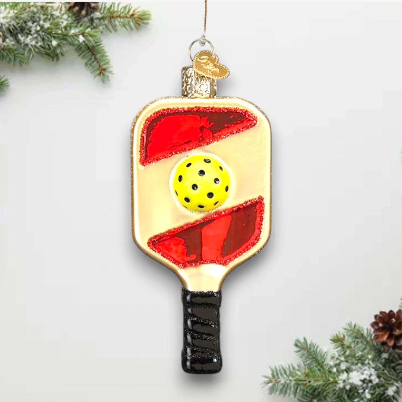 Pickleball paddle Christmas ornament featuring a yellow pickleball and vibrant red accents with glitter details, customizable with a name or year.