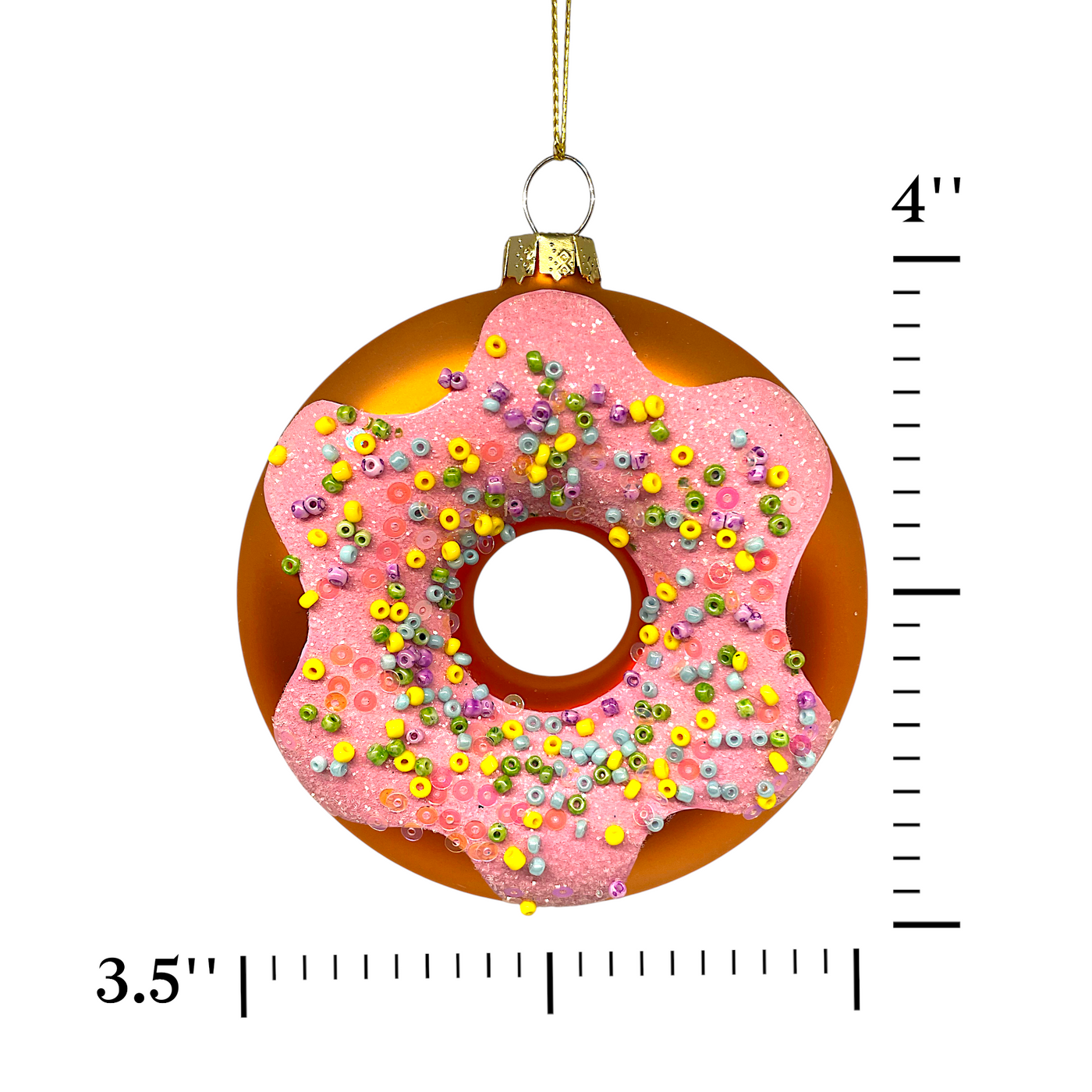 Decorative donut ornament with pink glaze and sprinkles, shown with a measurement ruler on a white background.