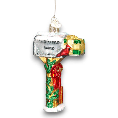 Festive mailbox Christmas ornament featuring a “Welcome Home” message, red cardinal, and holly decorations, accented with glitter details.