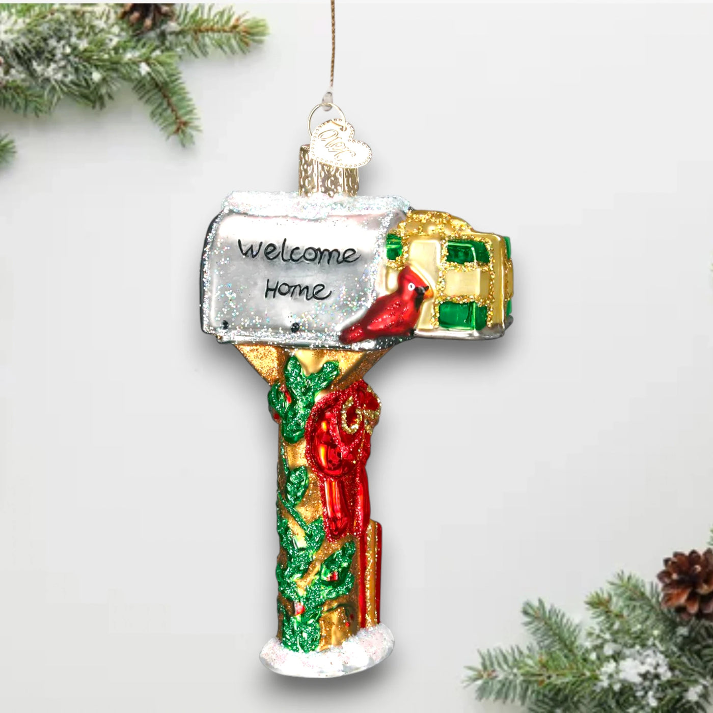 Festive mailbox Christmas ornament featuring a “Welcome Home” message, red cardinal, and holly decorations, accented with glitter details.