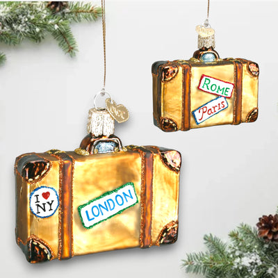 Golden suitcase Christmas ornament with travel destination stickers for Rome, Paris, London, and New York, decorated with glitter details.